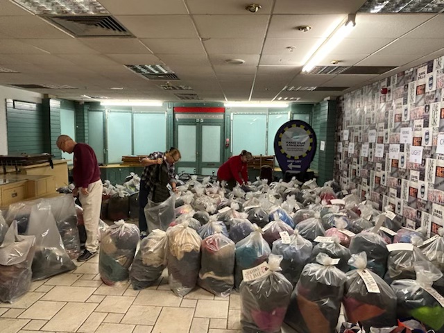 A room full of large see through bags full of coats.